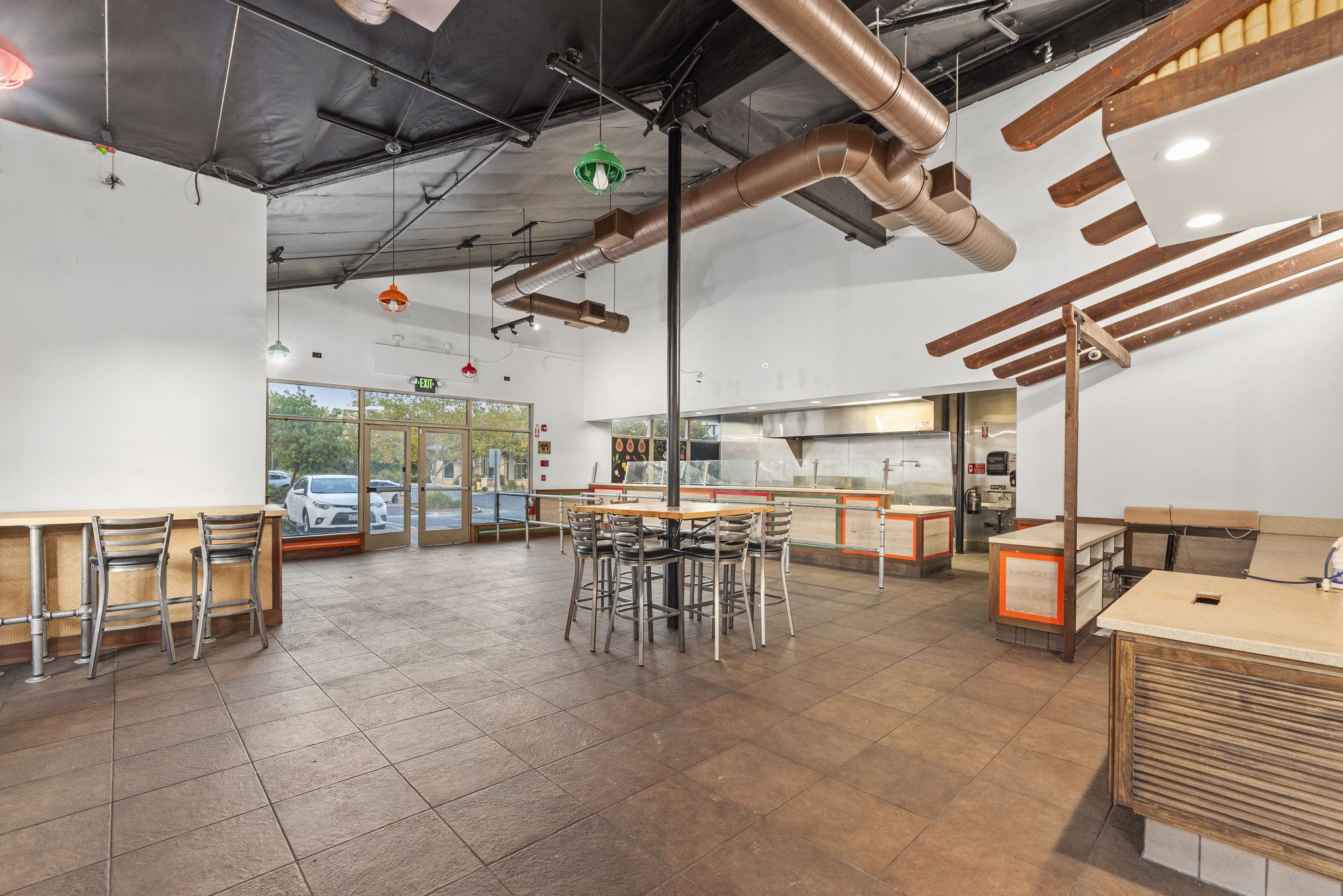 2,825 SF restaurant interior — copper ducts, exposed beams, banquette seating